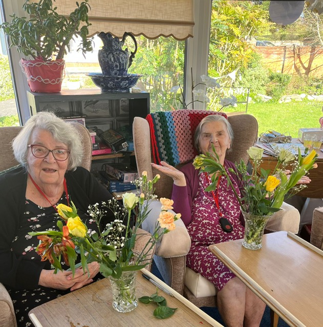 2 female residents with their arranged flowers