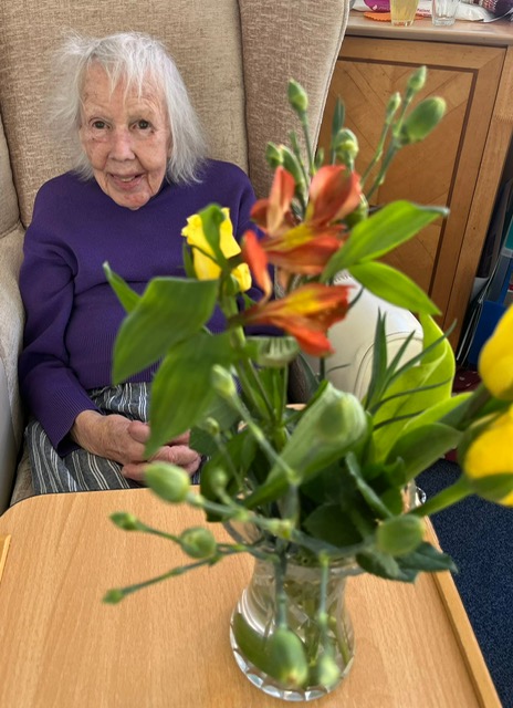 Female resident with vase of her arranged flowers