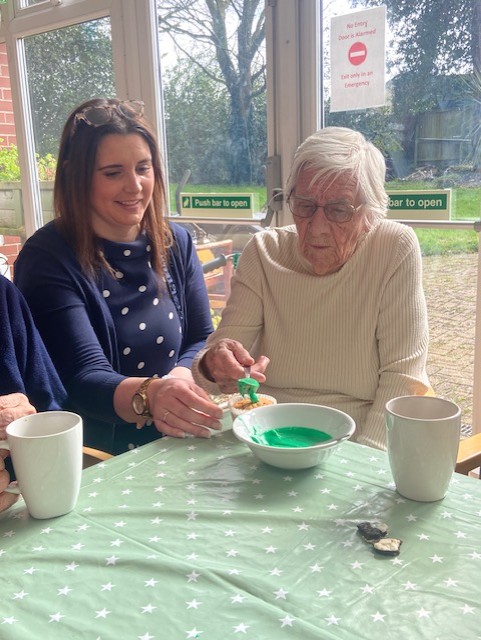 Resident putting green icing on a cupcake 1