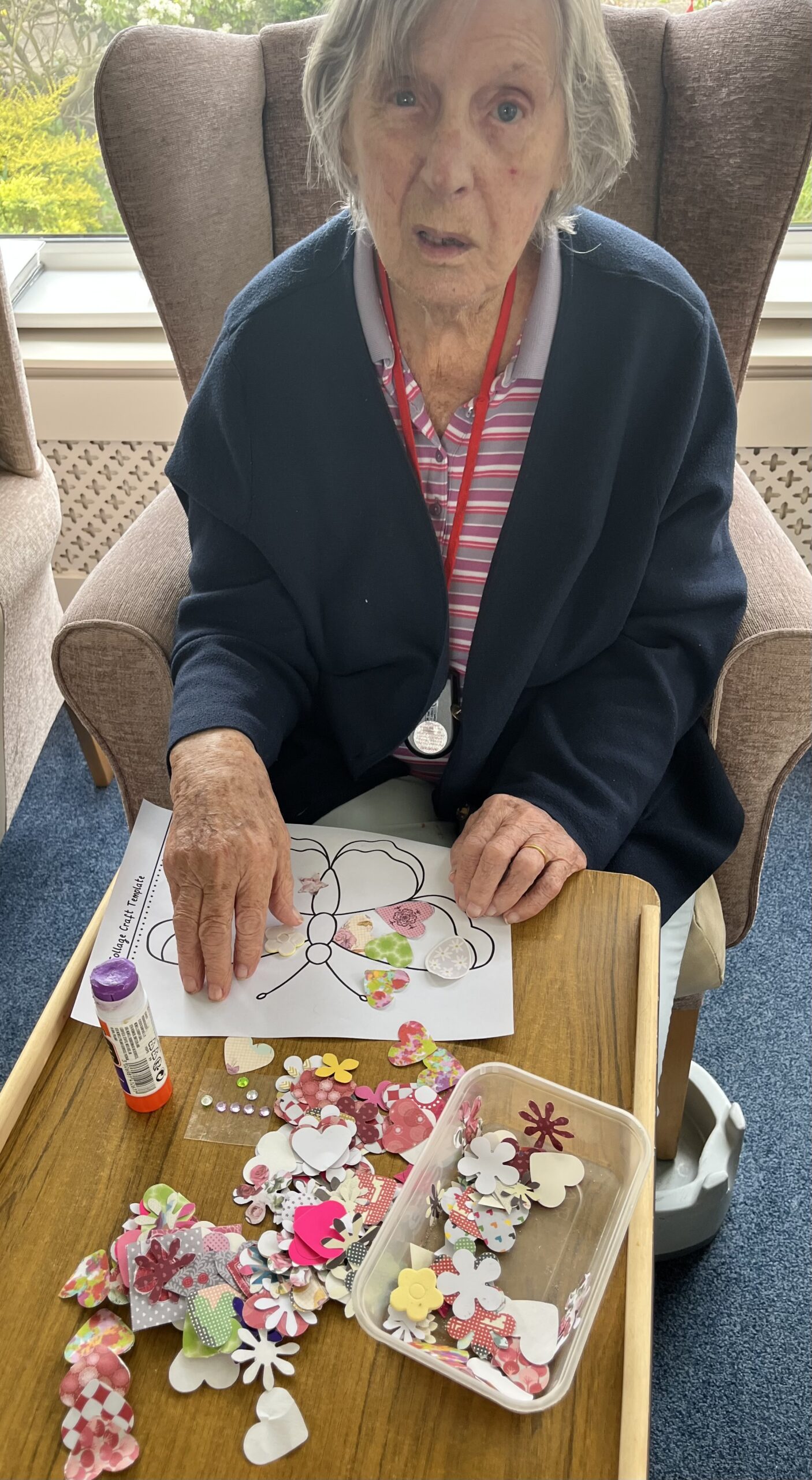Barb gluing paper patterned shapes to her butterfly scaled