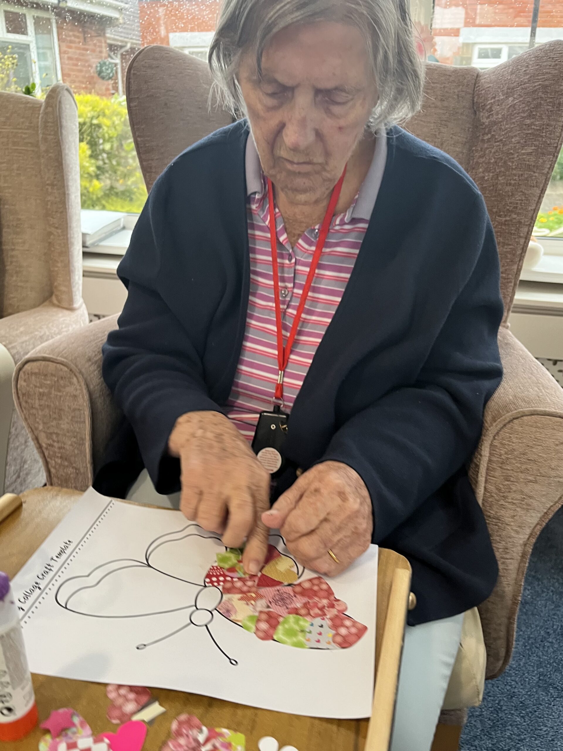 Barb sticking patterned paper to her butterfly scaled