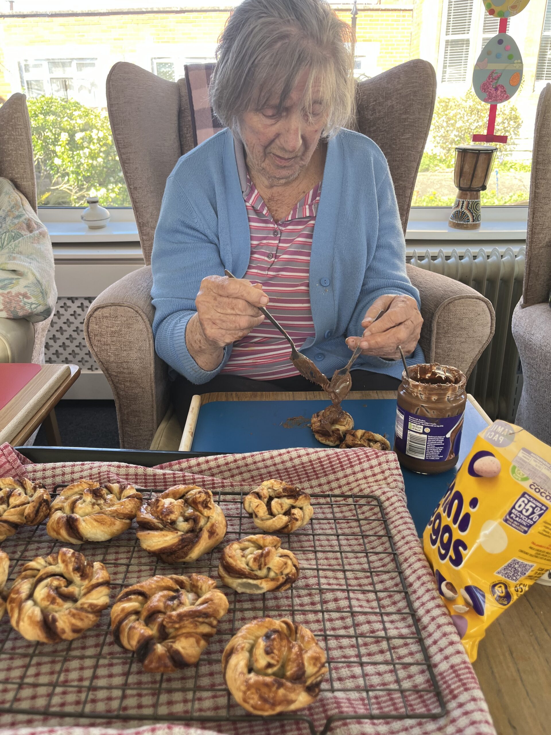 Barb topping the nests with chocolate spread and mini eggs scaled
