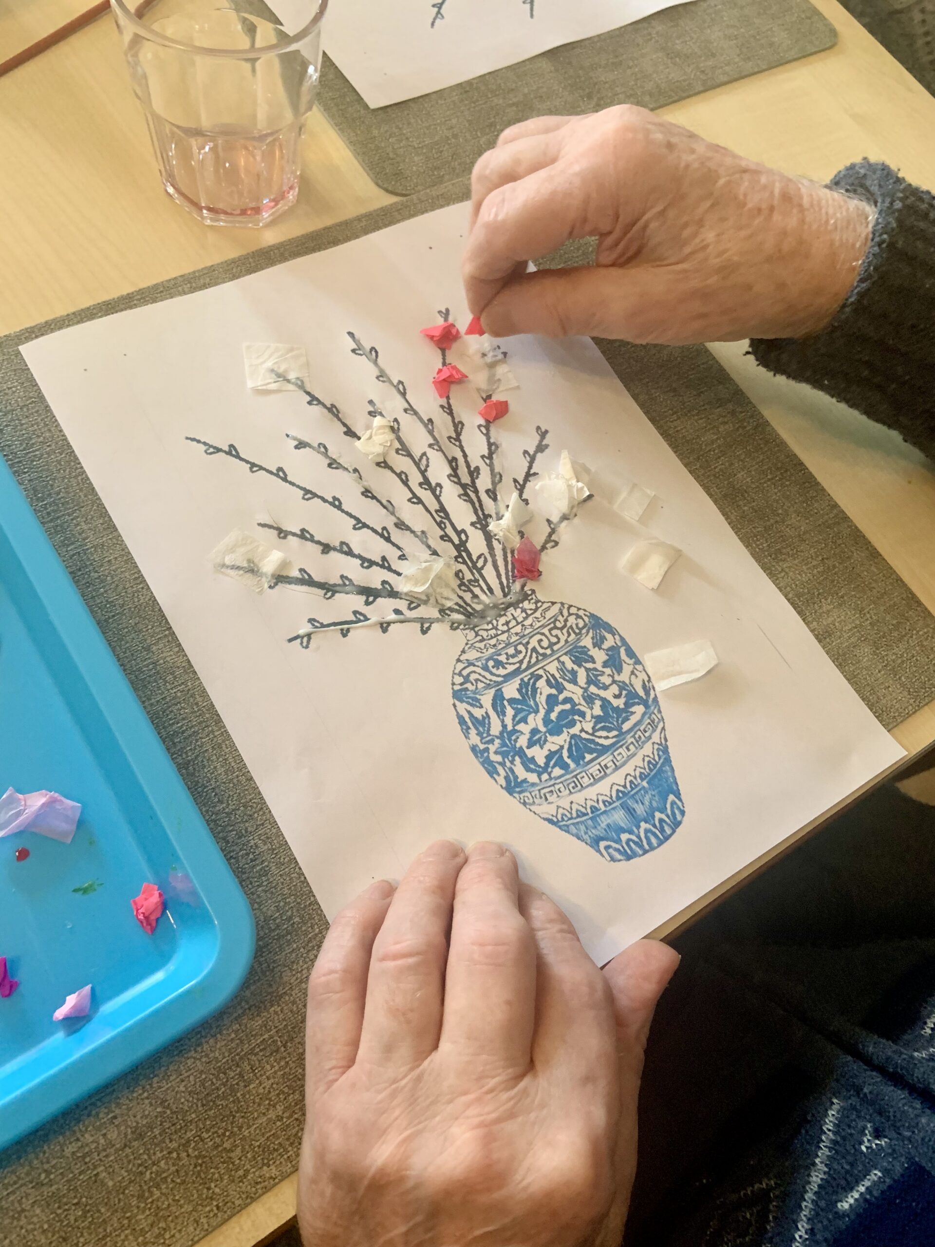 Close up of male resident placing tissue paper blossom on his picture scaled