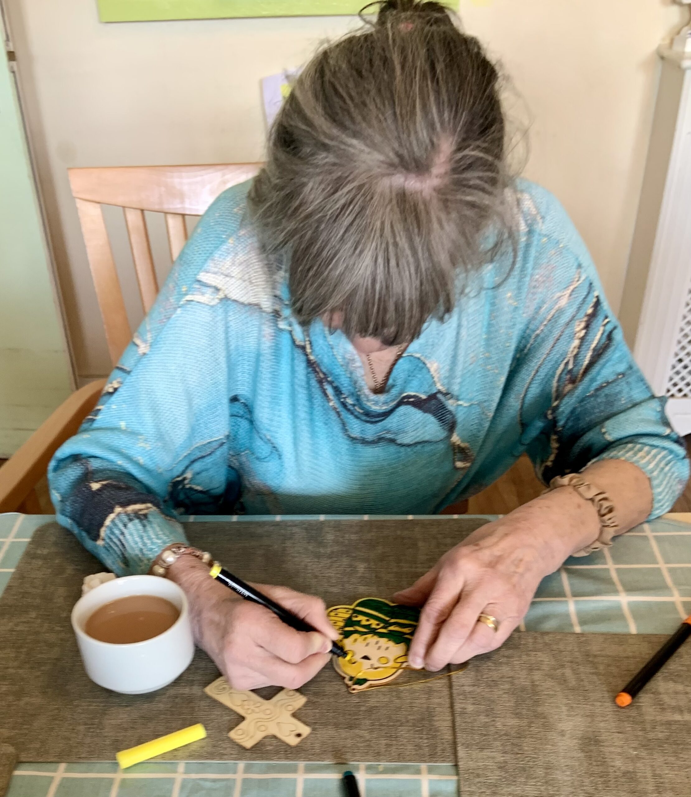 Female resident colouring in a paper chick with felt tip pens scaled