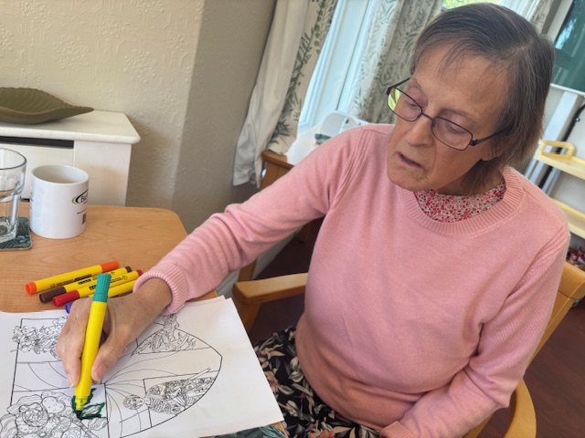 Female resident colouring in a shield with St Georges day motifs Female resident colouring in a shield with St Georges day motifs