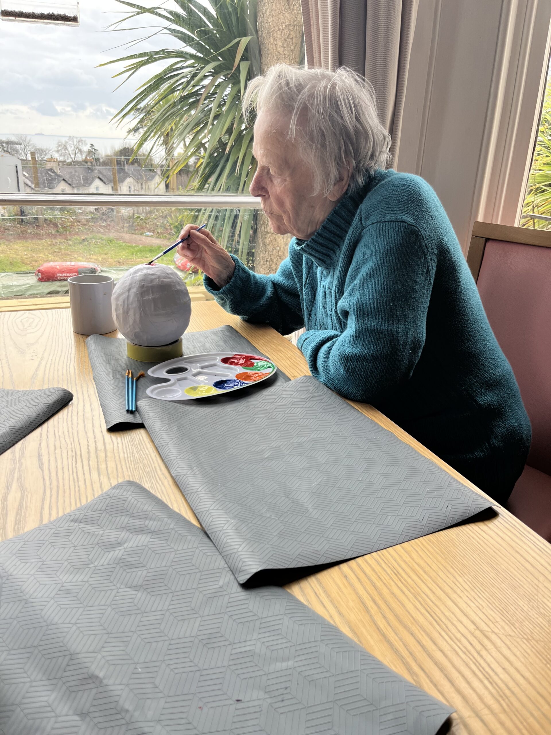 Female resident painting her Easter egg with red paint scaled