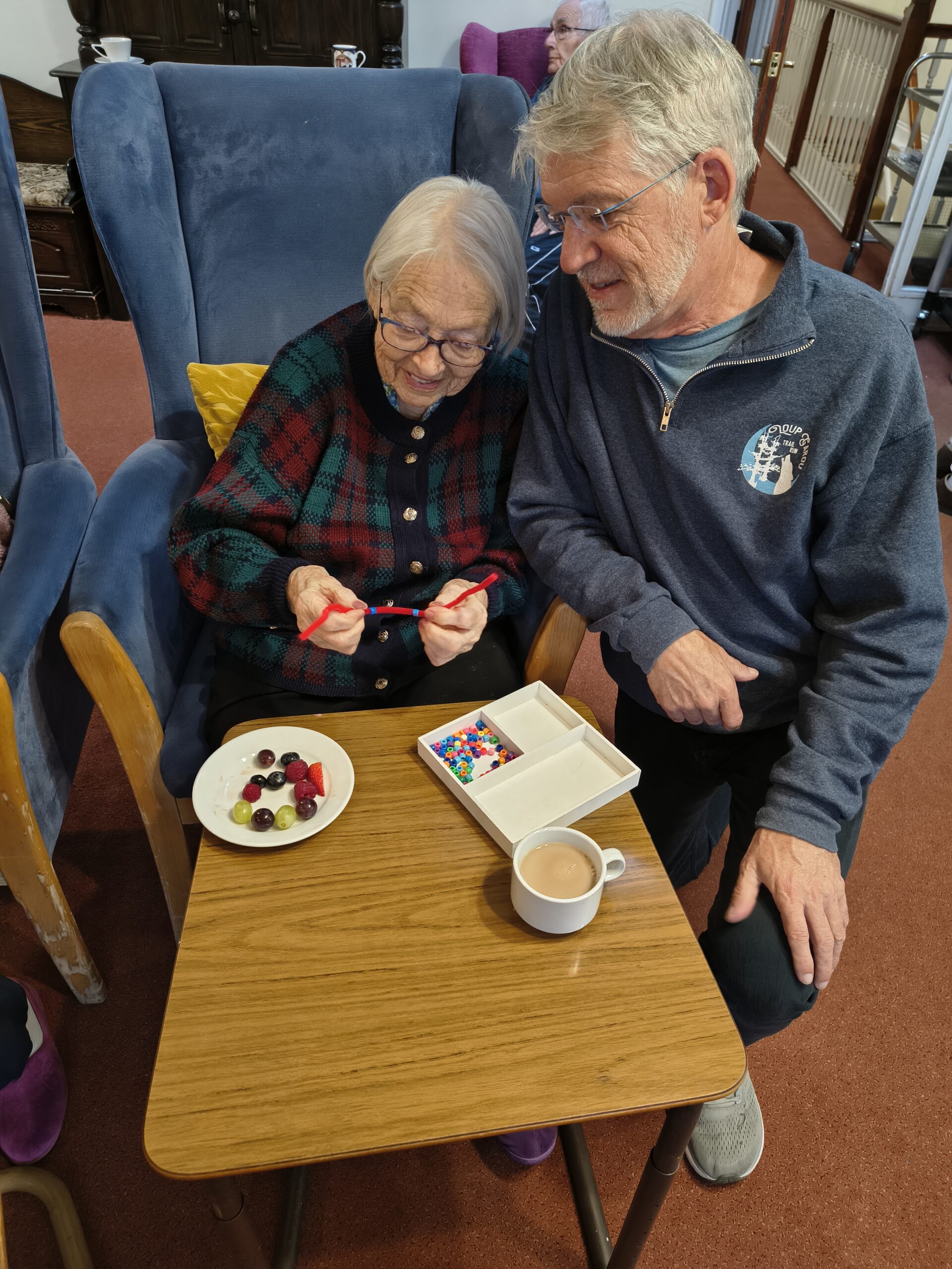 Female resident threading beads onto a pipe cleaner 4 scaled