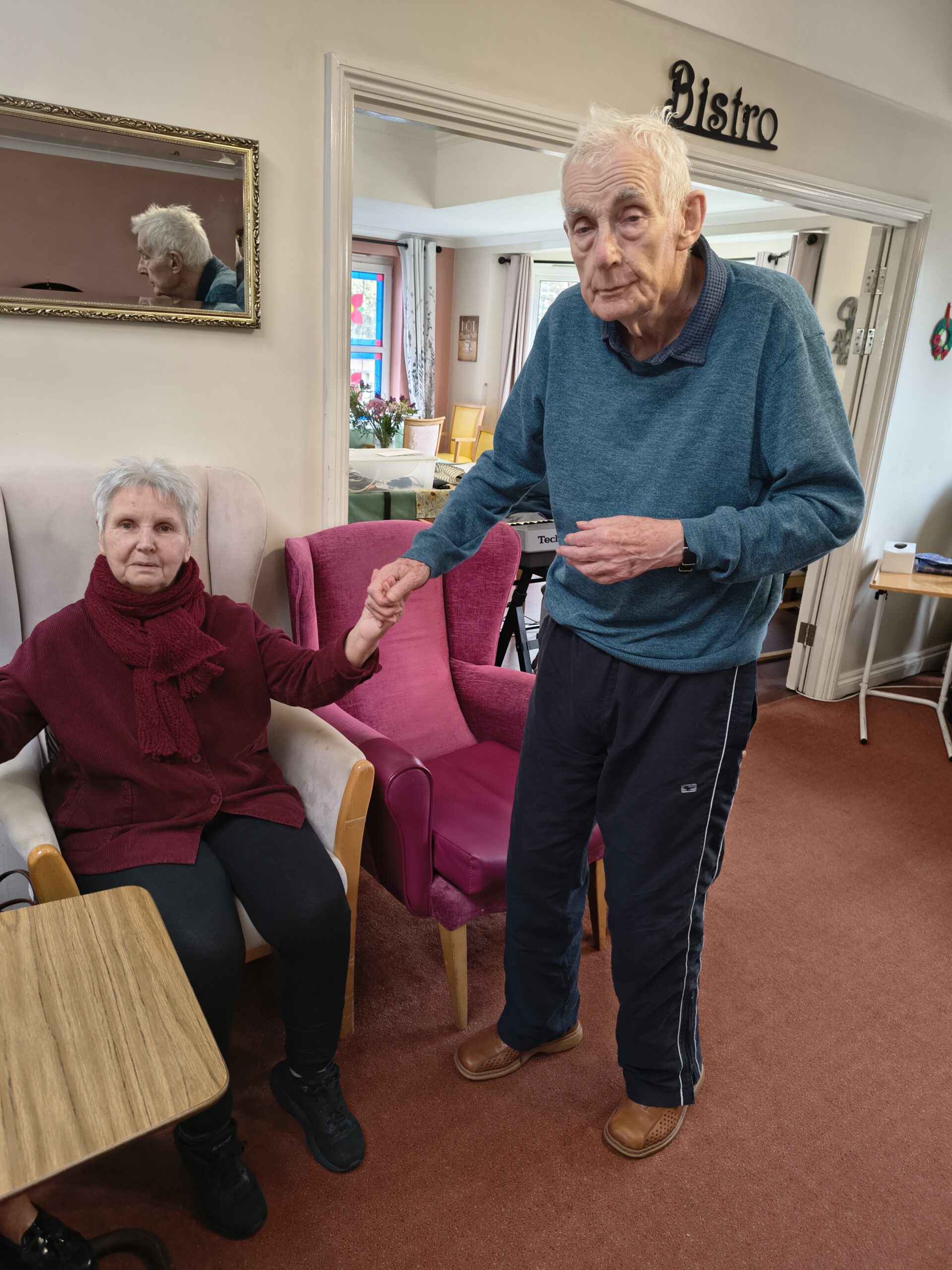 Male and female resident holding hands listening to the keyboard music scaled