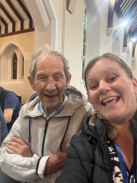 Male resident posing for a selfie with a carer in the church rotated