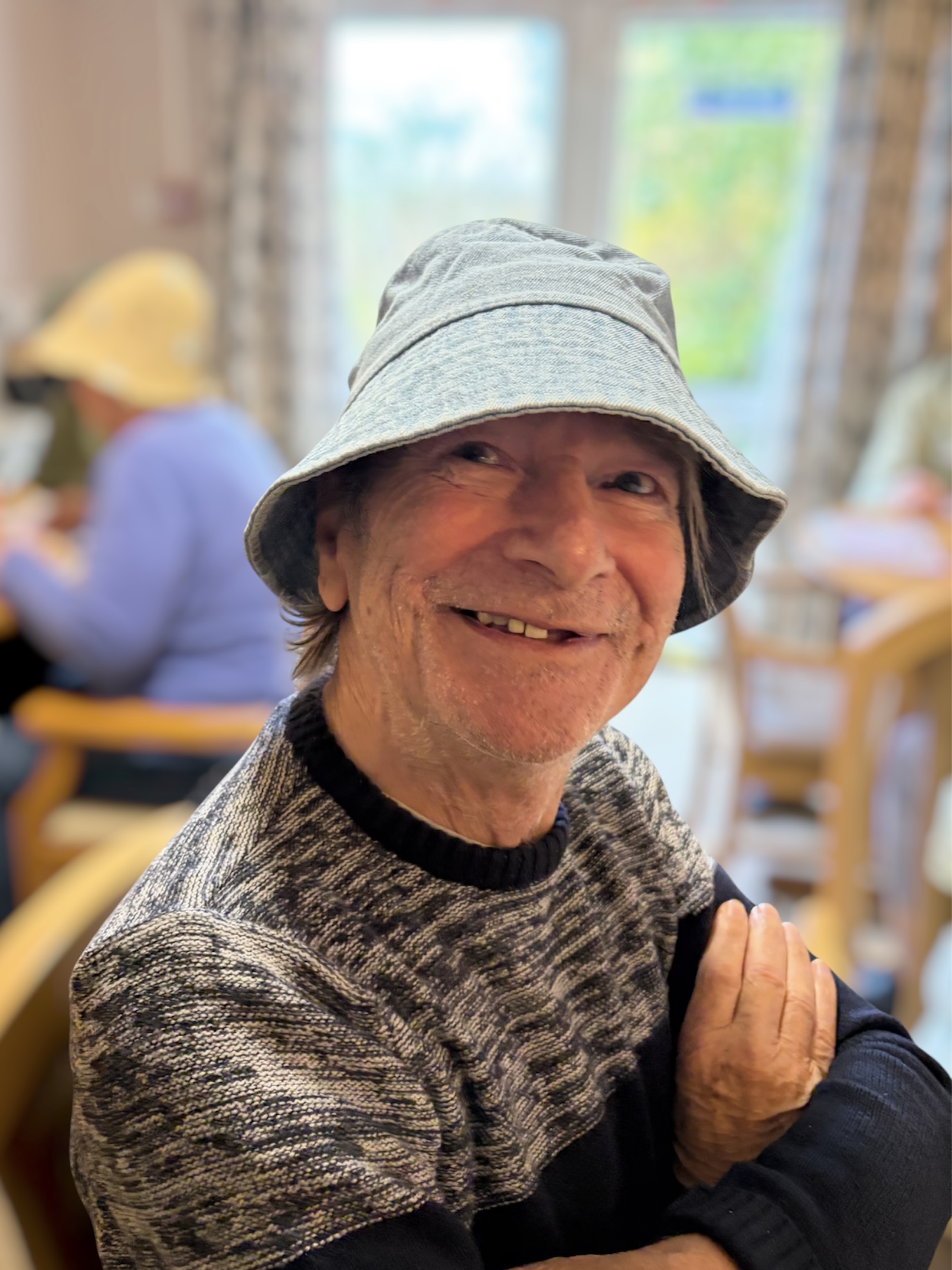 Male resident wearing a grey bucket hat smiling
