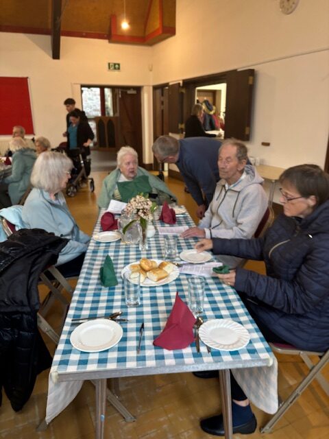 Residents seated around a table chatting rotated