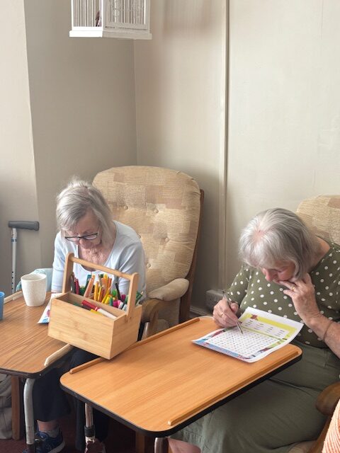 Two female residents doing a St Georges day themed word search puzzle Two female residents doing a St Georges day themed word search puzzle rotated