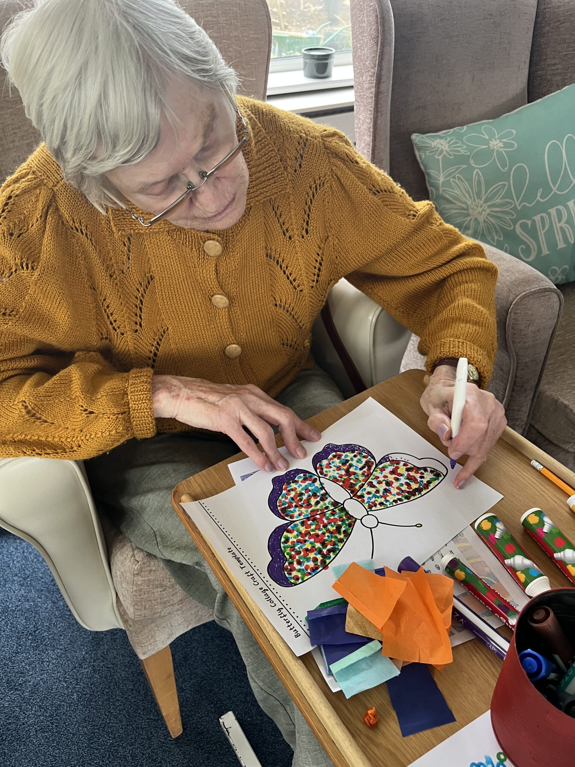 Wendy adding texture to her butterfly artwork with felt tip pen and tissue paper scaled
