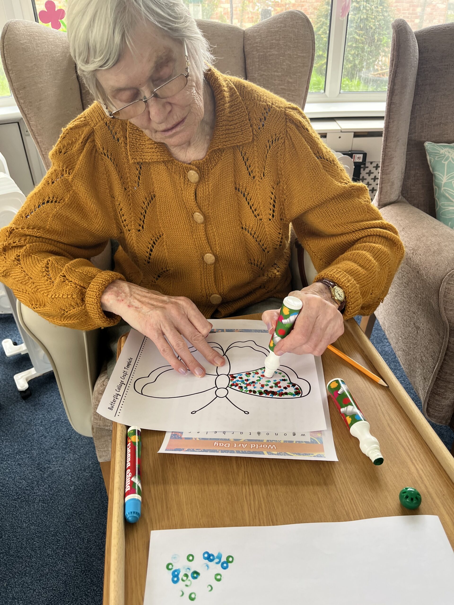 Wendy putting dots on colour on her butterfly with felt tip pen scaled