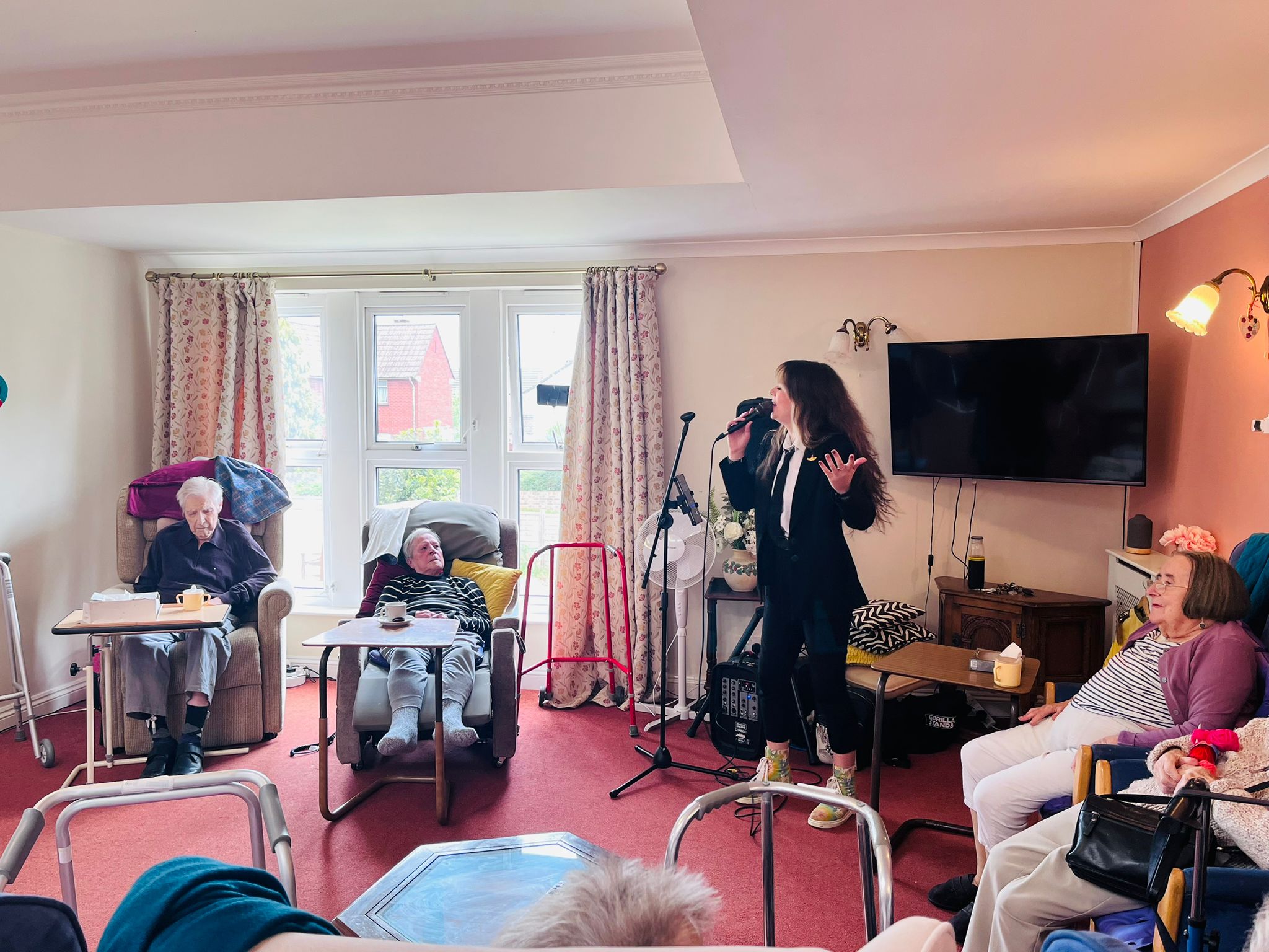 A lady singing as residents watch