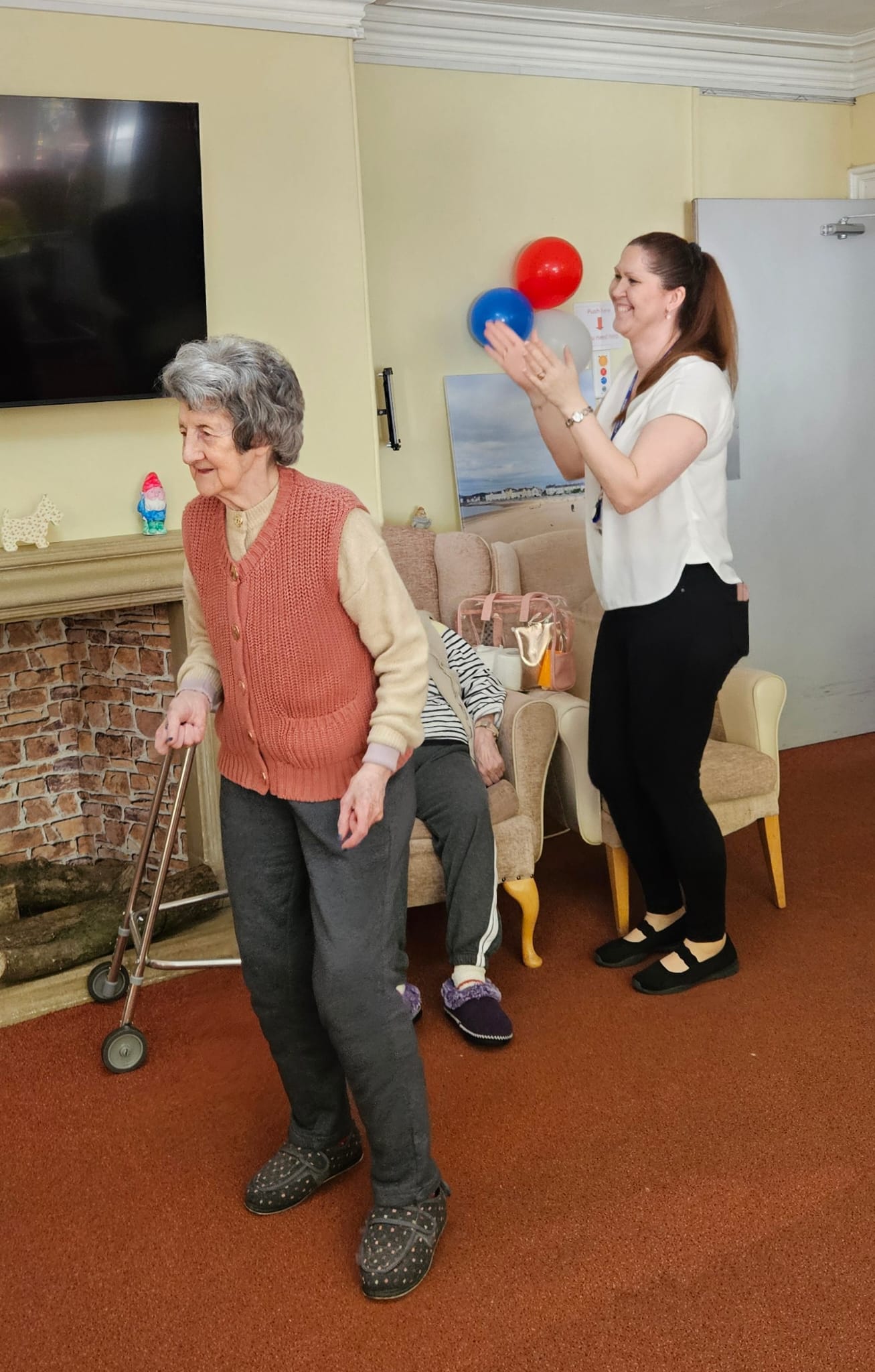 A resident dancing and a carer clapping along to the music
