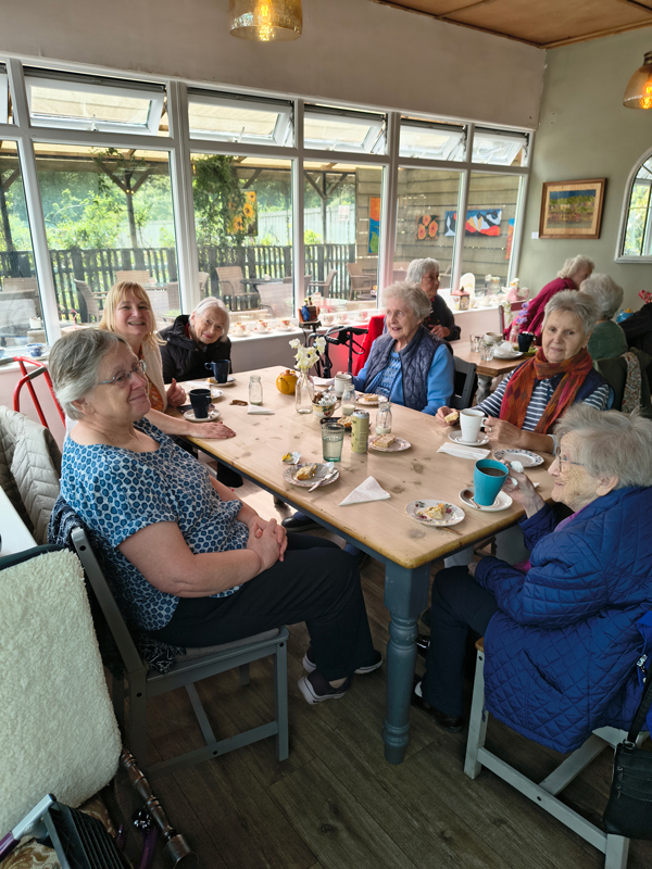 All residents seated around the table with tea and cake