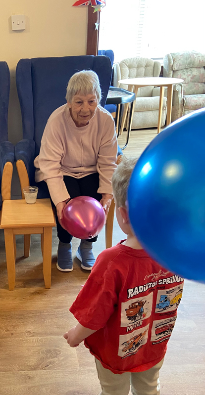 Ange throwing a balloon to one of the children