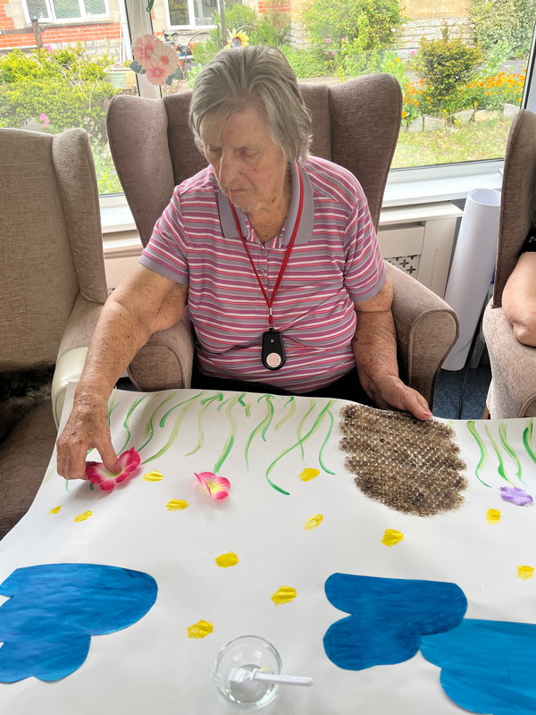 Barb sticking flower petals to the poster