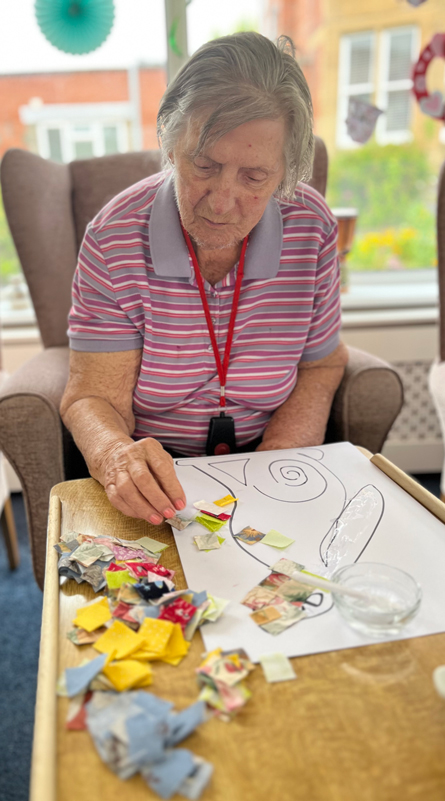 Barb working on her hare patchwork sticking on squares of paper