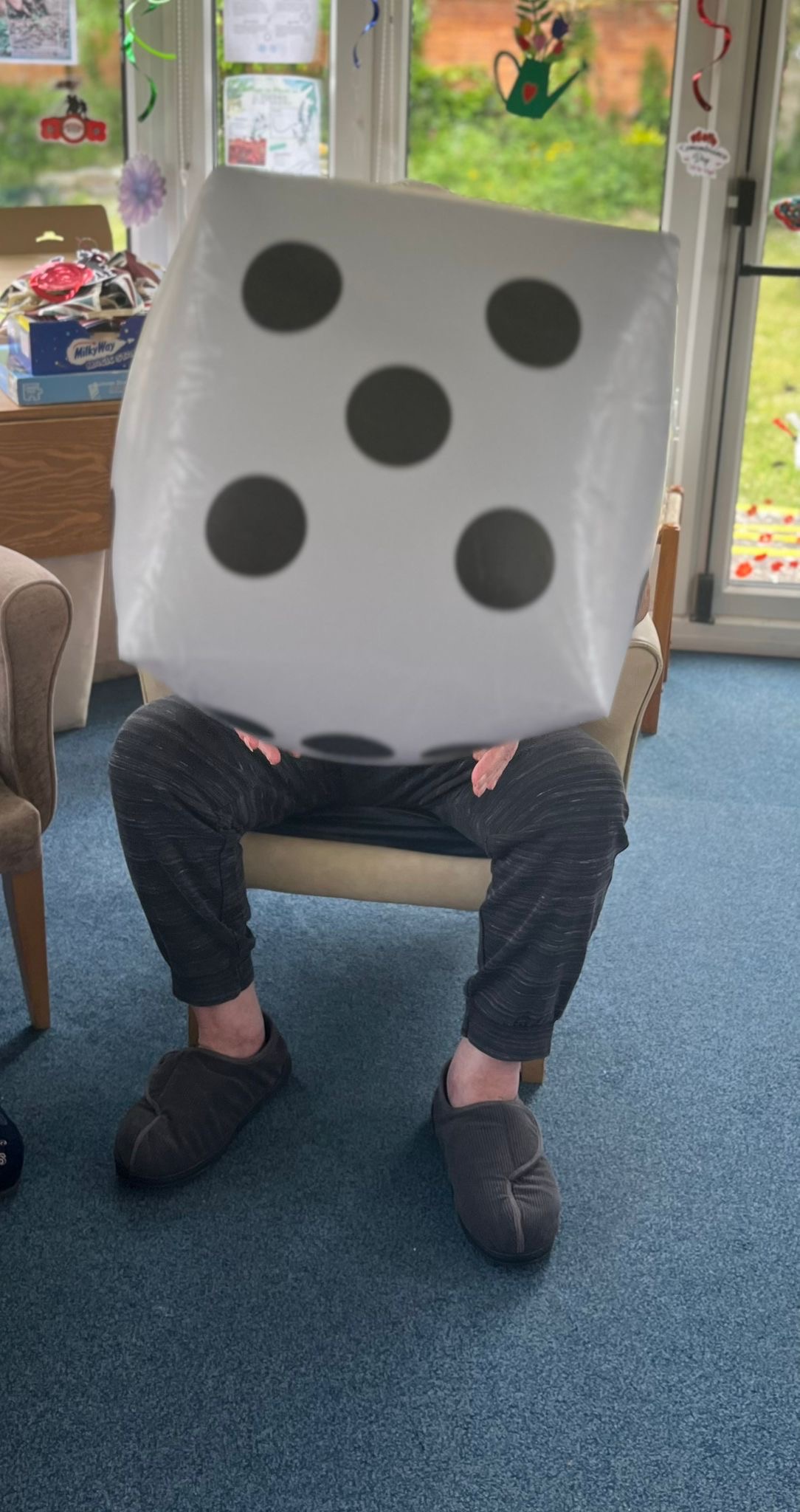 Bill seated holding a large blow-up dice Bill seated holding a large blow up dice