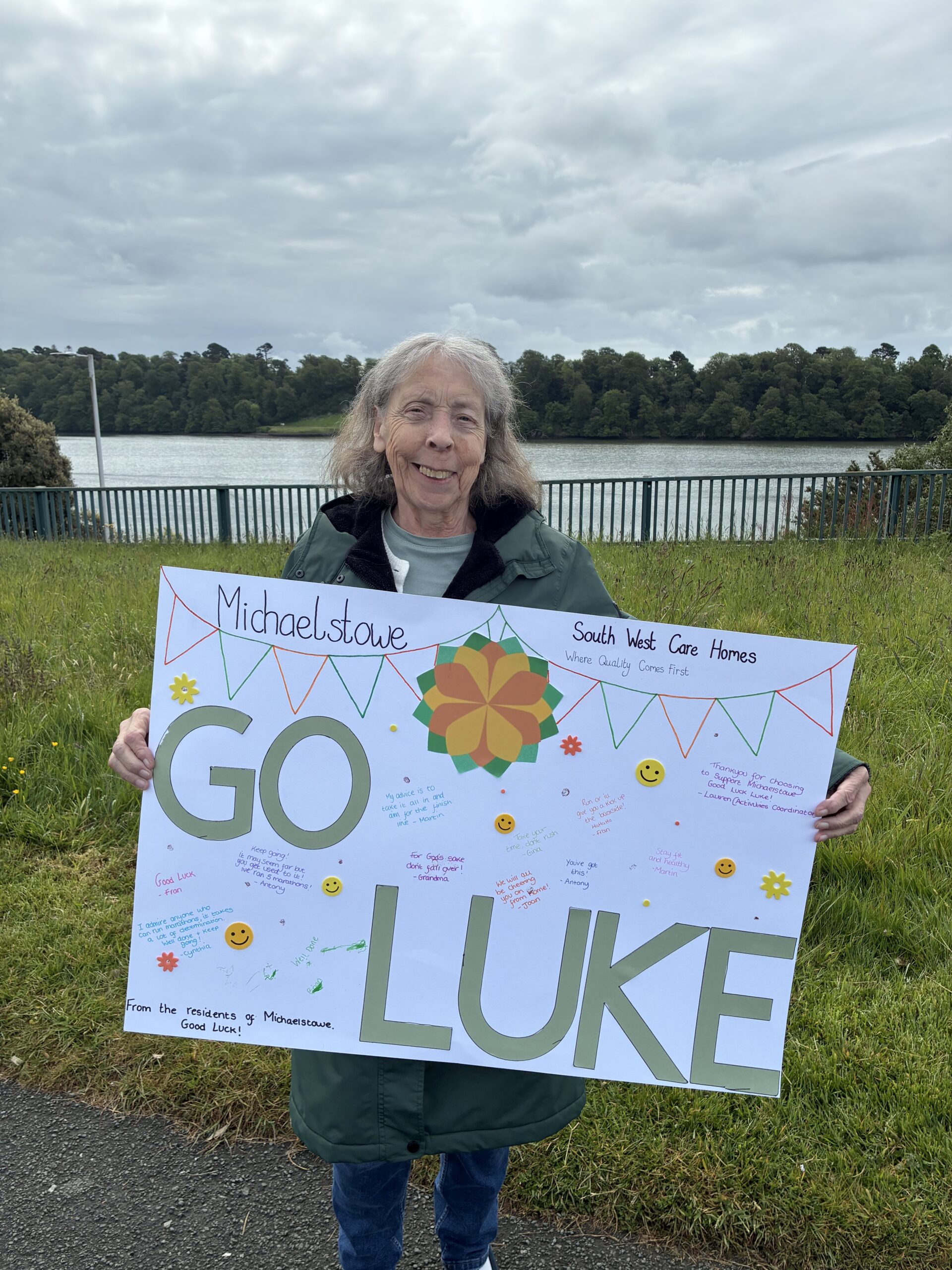 Carol outside holding a homemade Go Luke sign scaled