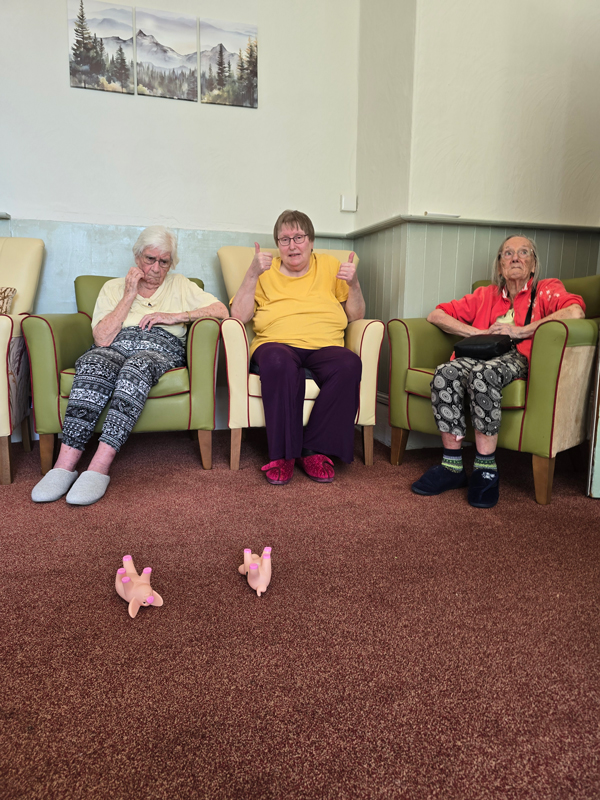 Chris giving the thumbs up as her pigs land on the floor as Shirley and Barbara watch