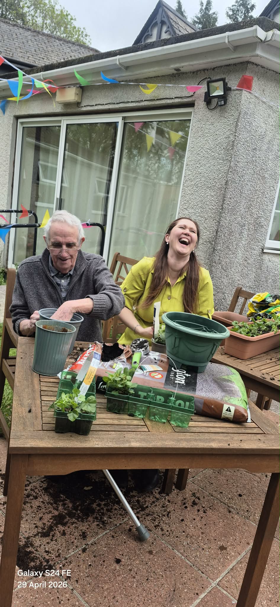 David and Janka laughing whilst putting soil in plant pots