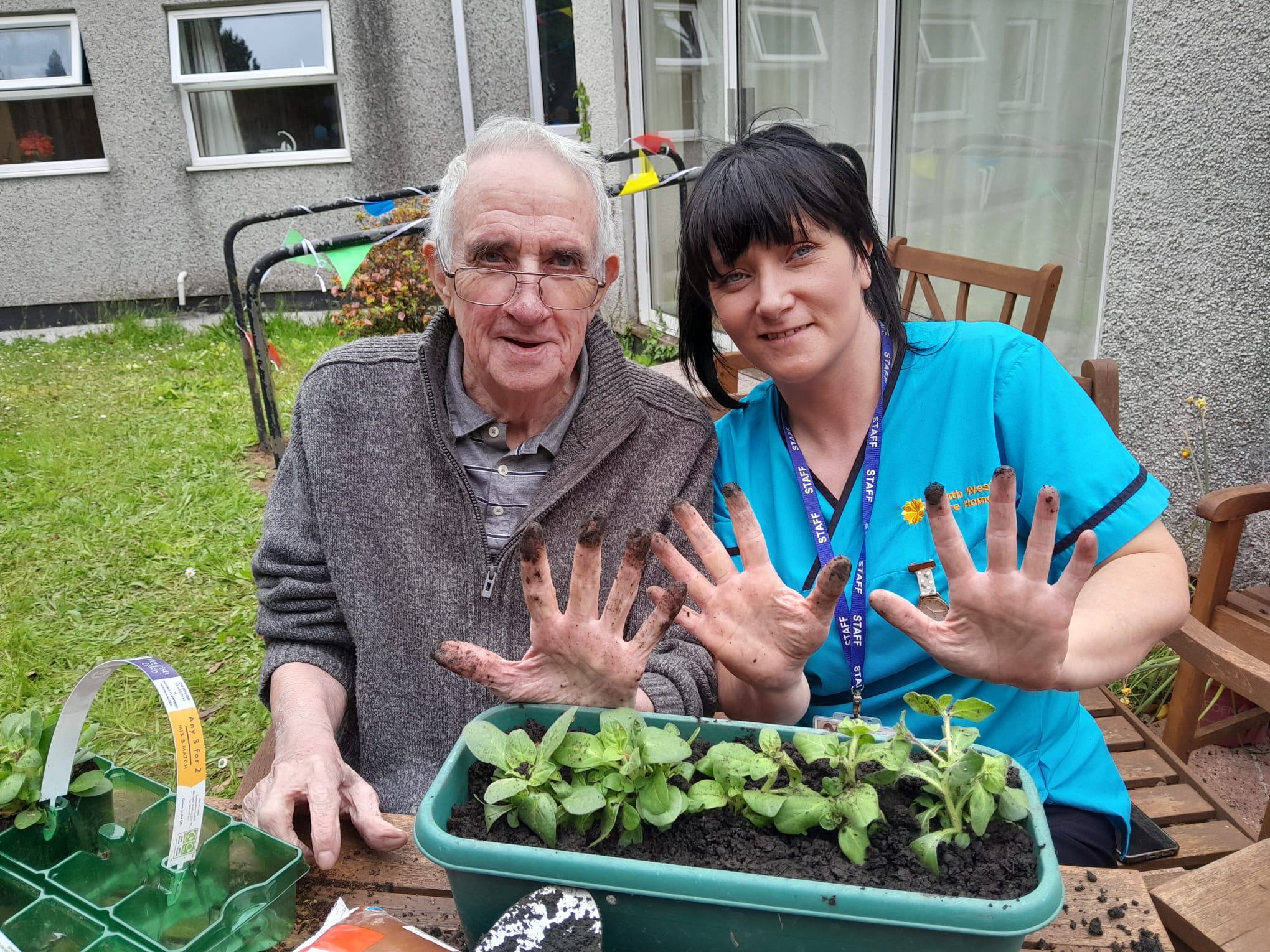 David and carer Billie with soil covered fingers after planting