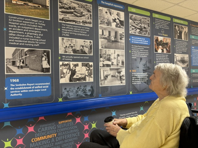 Doris reading a display board of hospital archive