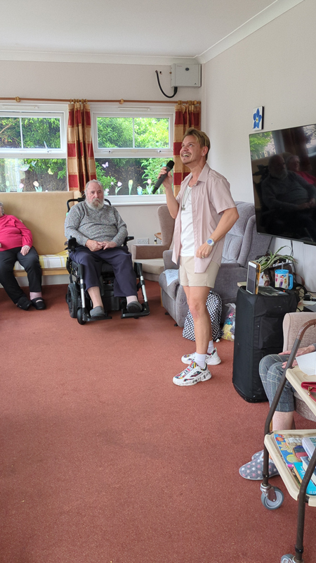 Duane singing surrounded by the residents