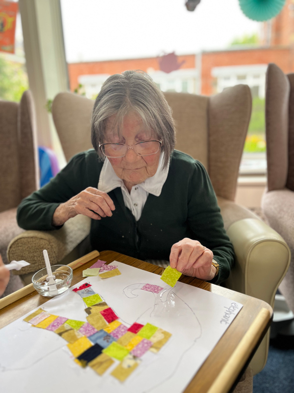 Eileen placing a square onto her patchwork elephant