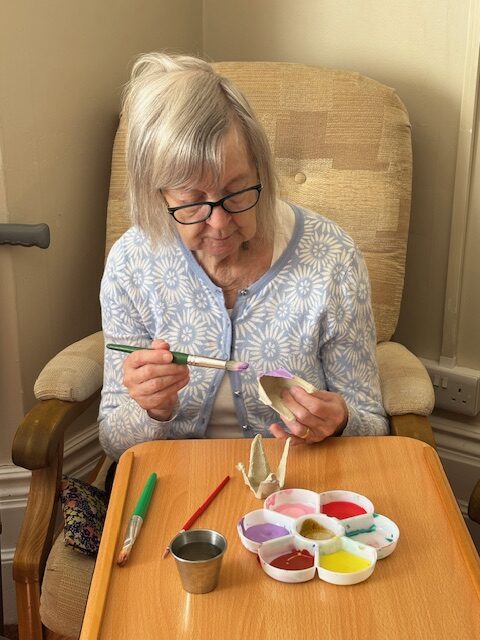 Female resident painting part of an egg box lilac rotated