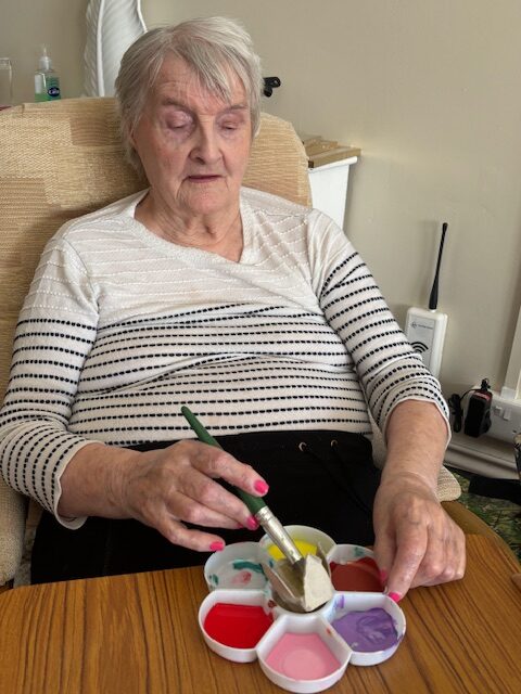 Female resident painting part of an egg box rotated