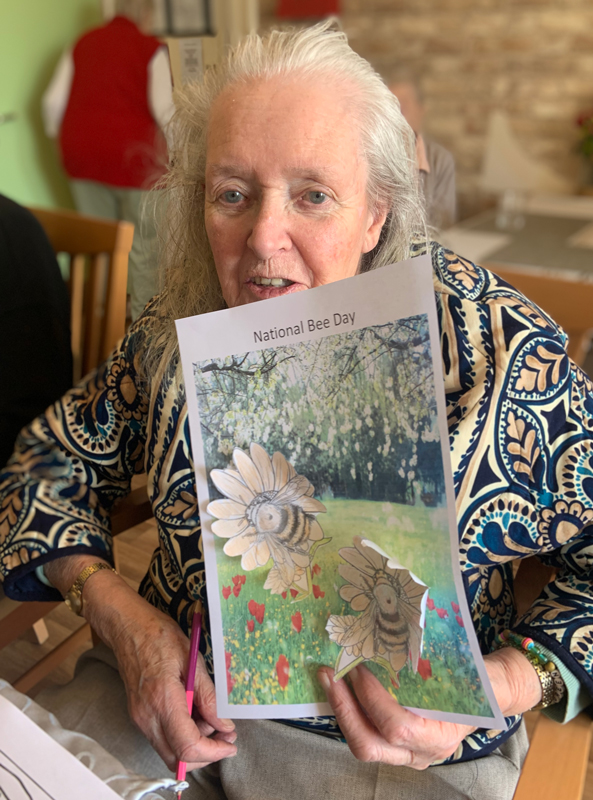Female resident proudly holding up her finished picture