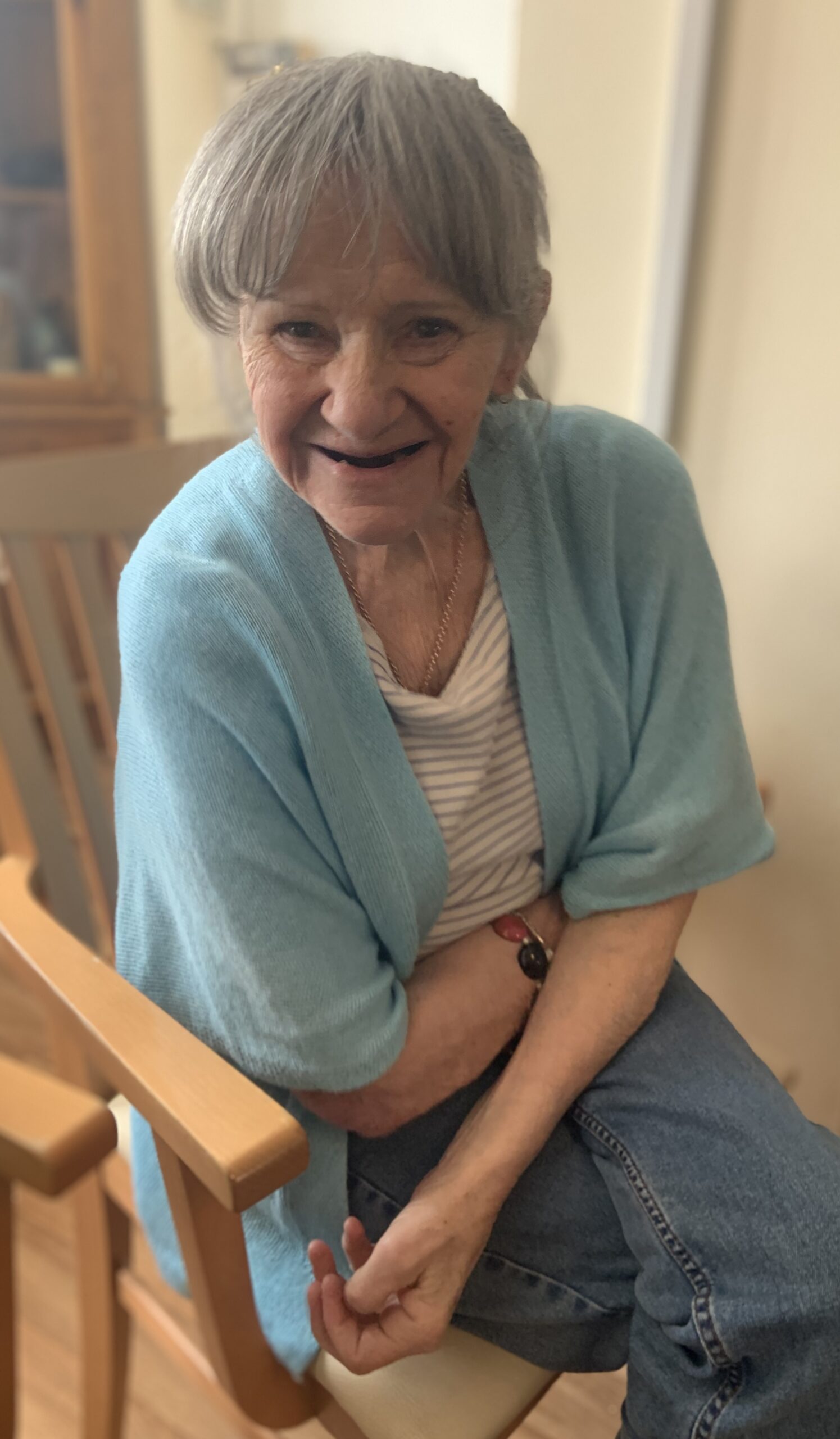 Female resident seated smiling for the camera scaled
