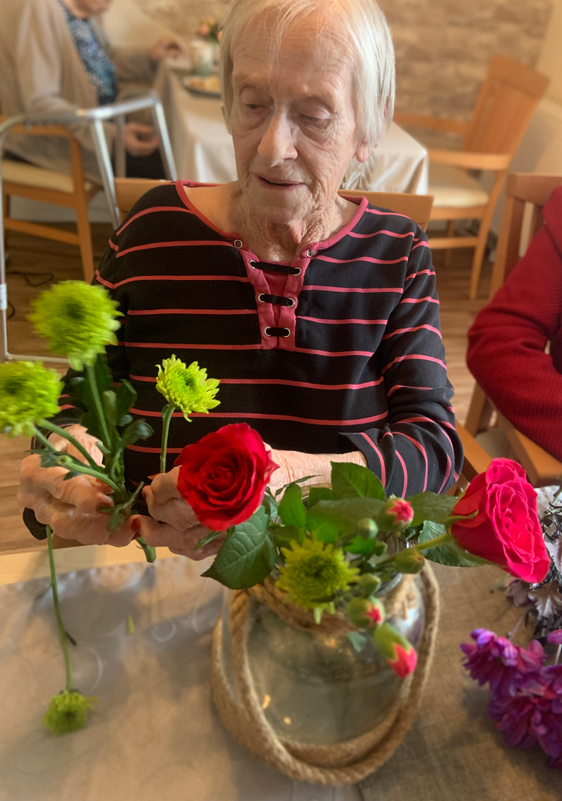 Female resident separating flowers to put in her glass vase