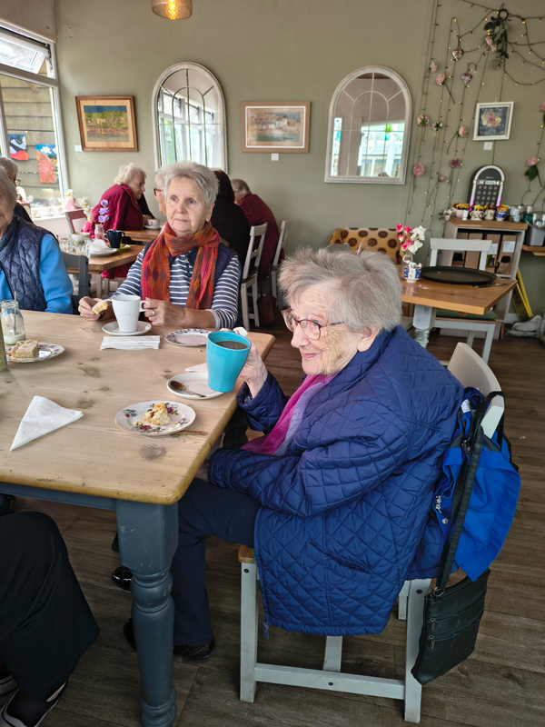 Female resident sipping coffee and smiling