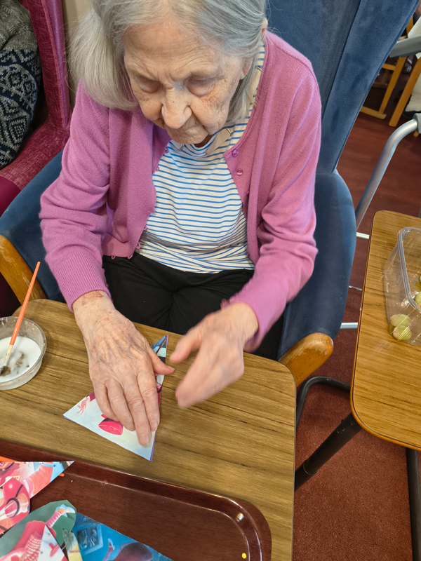 Female resident sticking an image of the Mad Hatter to her bunting