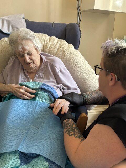 Female resident with her eyes closed enjoying the hand and arm massage rotated