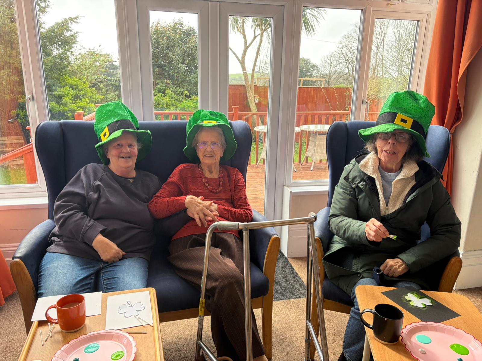 Group of residents seated together smiling all wearing leprechaun hats