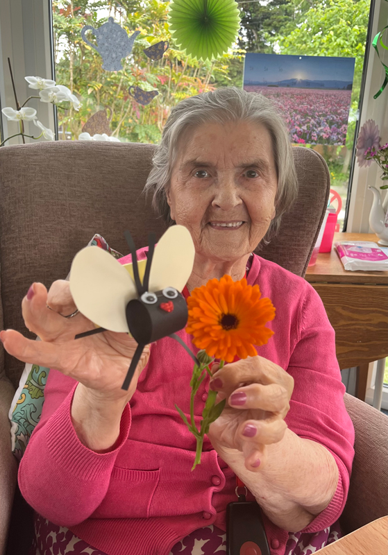 Harta holding up finished paper bee and a flower