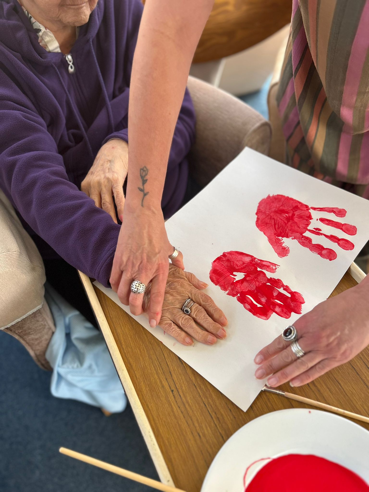 Herta pressing her painted hand onto paper