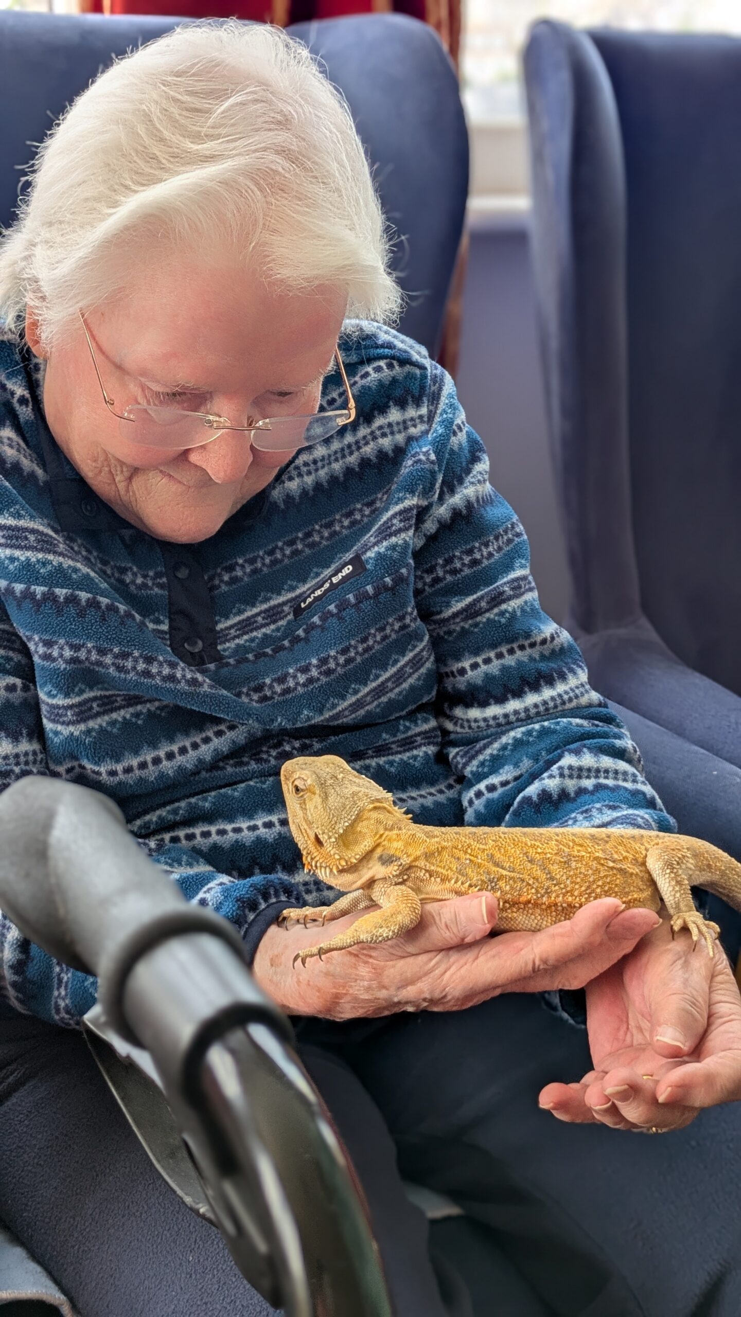 Lyn holding a bearded dragon smiling at it scaled