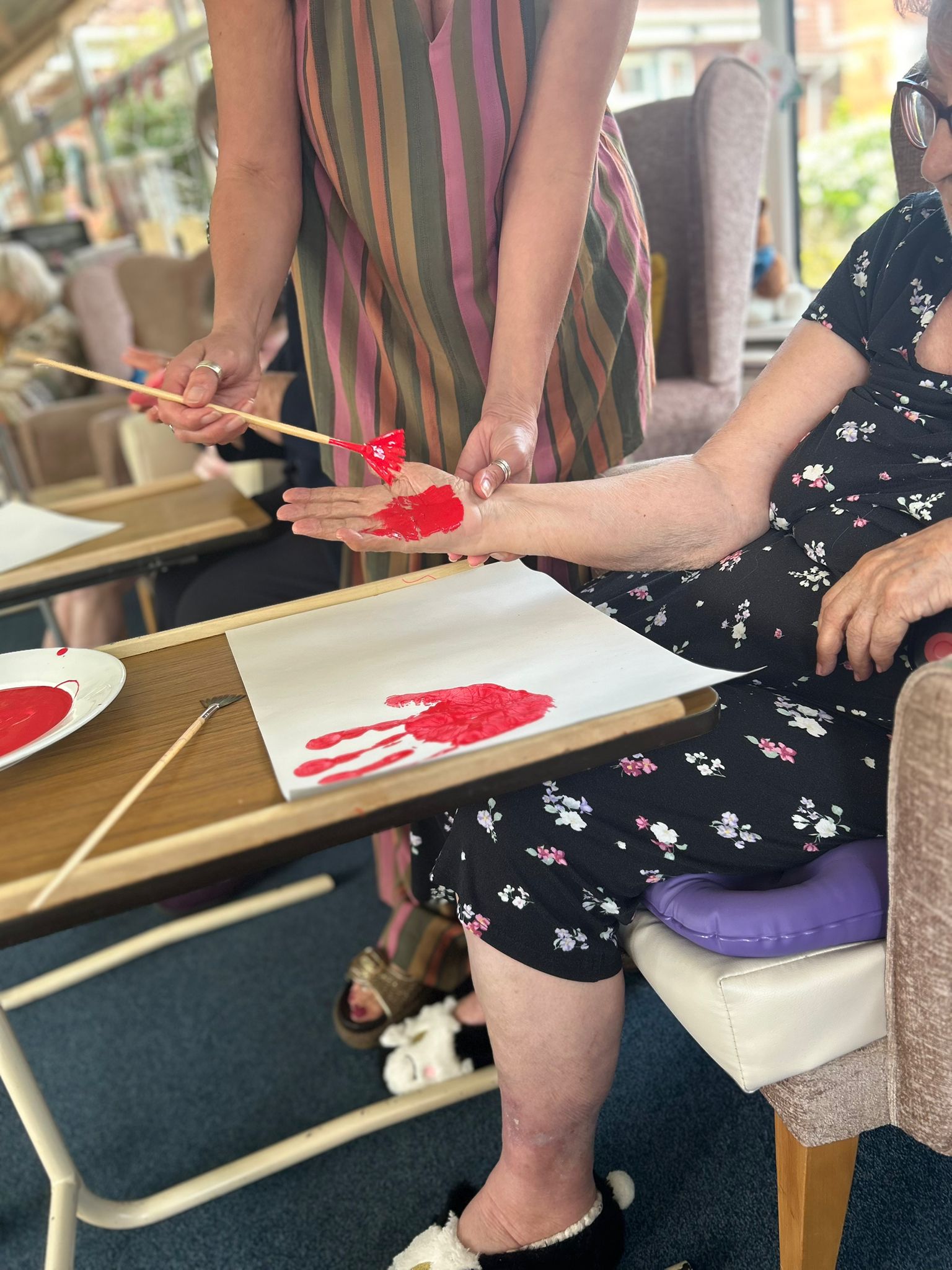 Maggie having her hand painted red ready to print