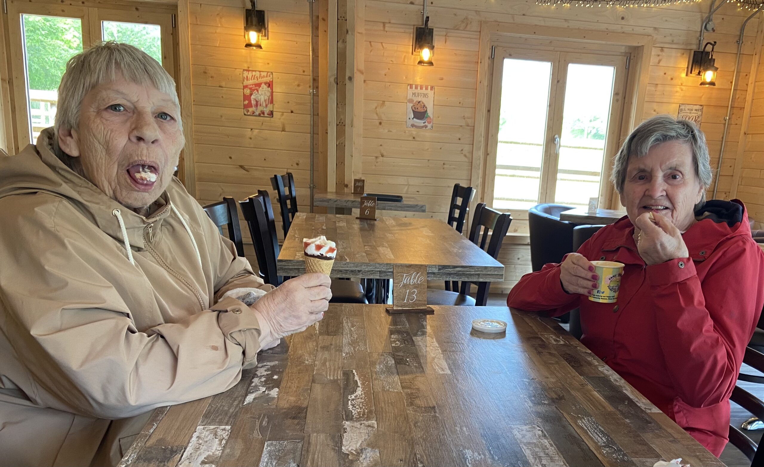 Marj and Ange seated in a cafe eating ice cream scaled