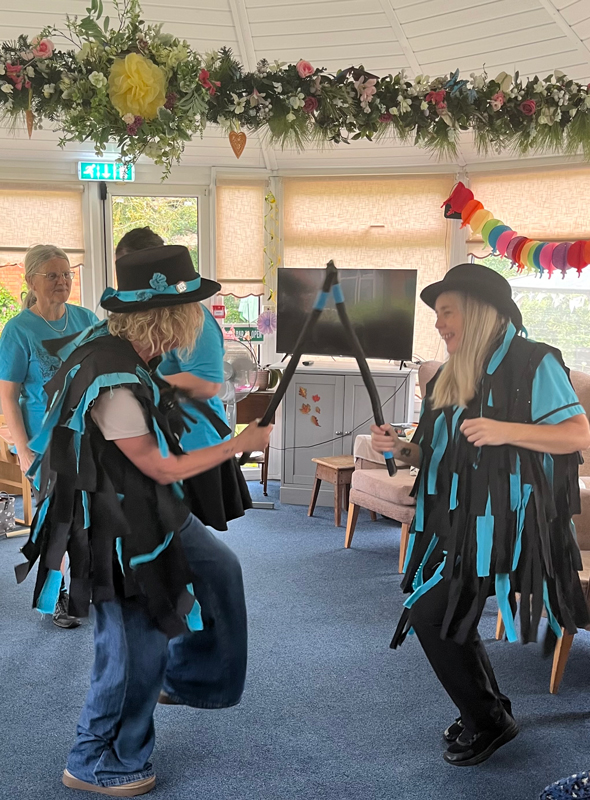 Morris dancers dancing banging their sticks