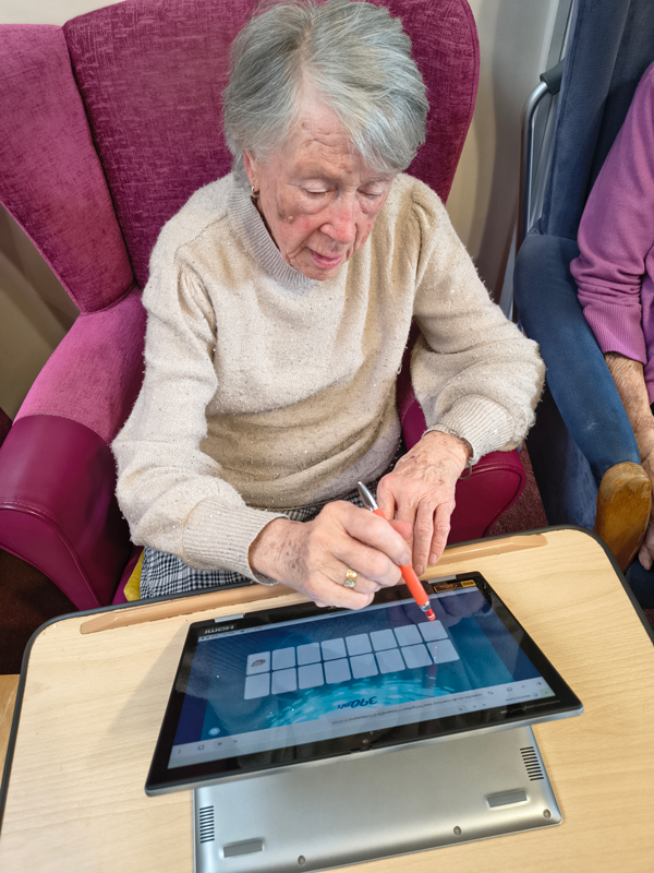 Other female resident tapping the screen to find pairs of cards