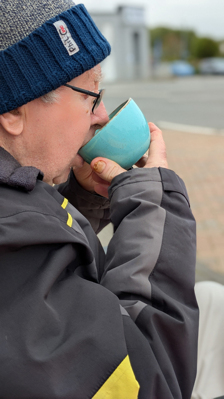 Phil outside drinking a cup of coffee