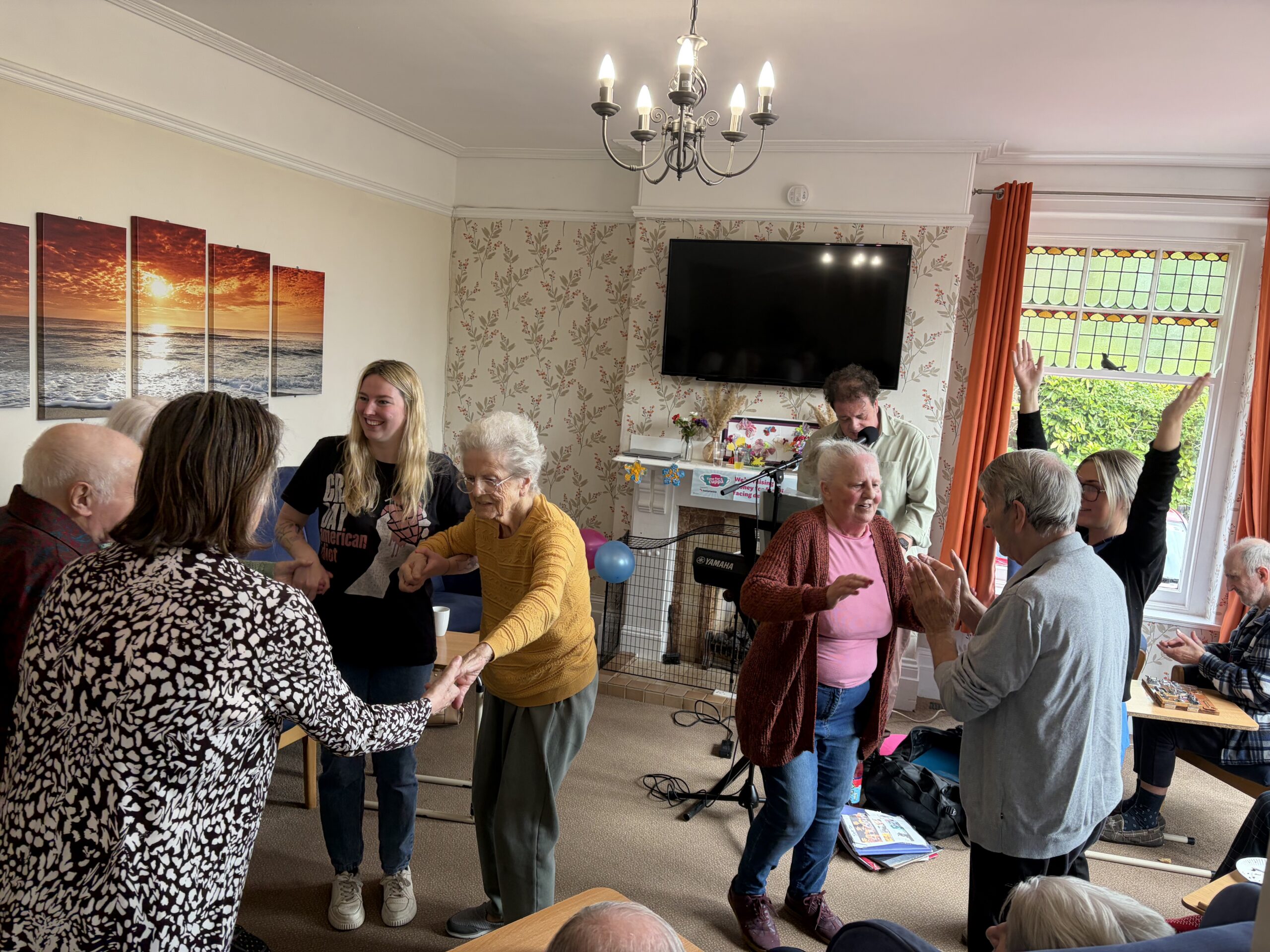 Residents and staff dancing to live music in the lounge scaled